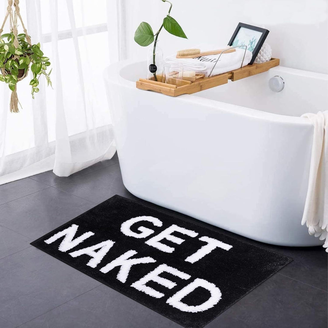Blød tuftet bademåtte med "Get Naked" tekst i moderne design for et stilfuldt og komfortabelt badeværelse.
